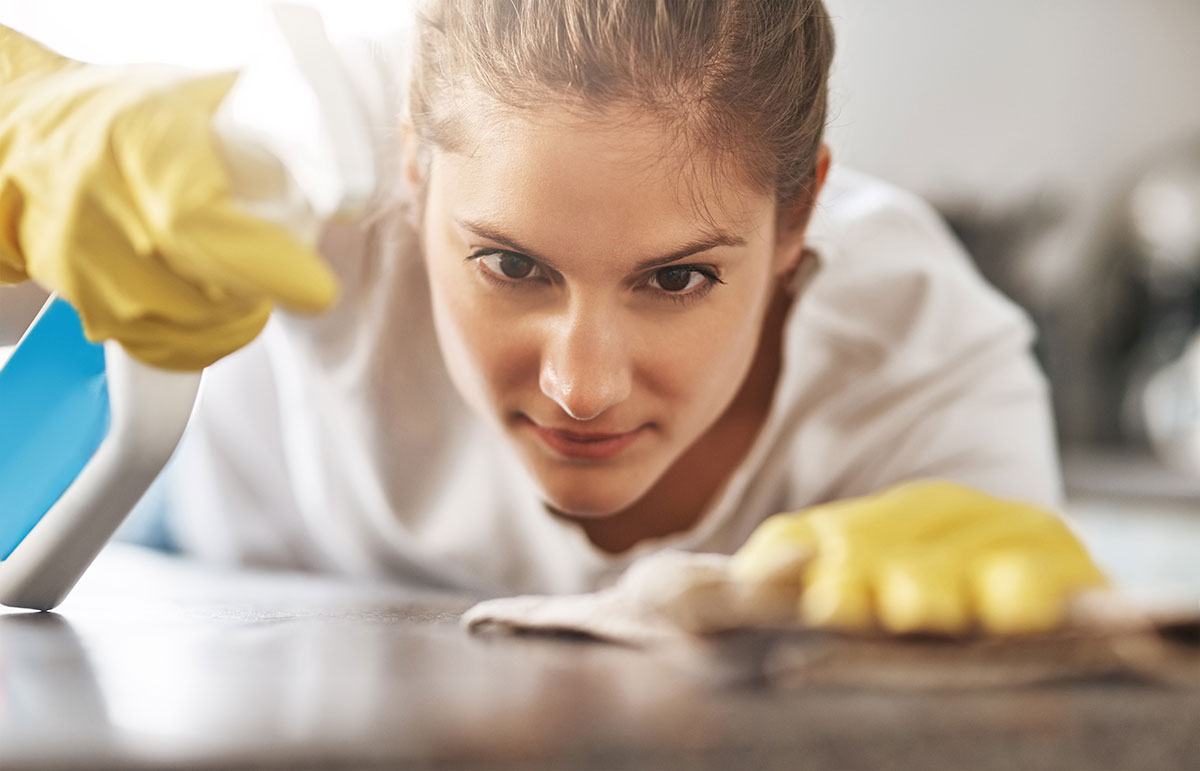 Woman looking forward while cleaning a surface