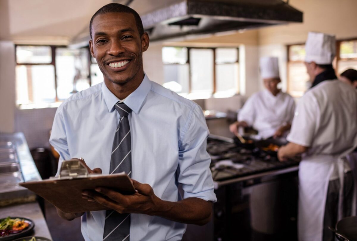 Manager with clipboard in kitchen