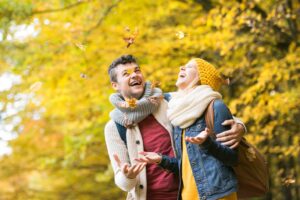 Couple enjoying autumn leaves