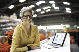 Woman sat at a desk with a laptop open.