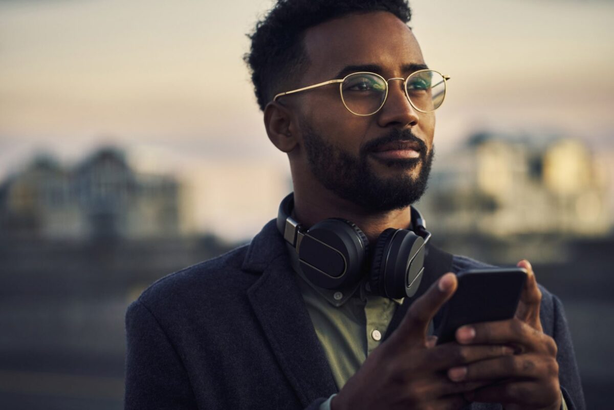 A man outside with headphones and a mobile device