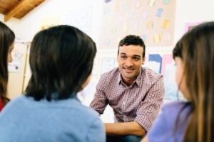 Teacher Counselling students in Classroom