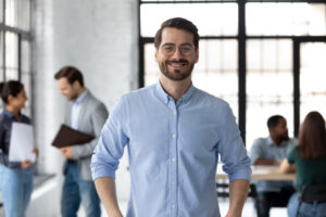 Portrait of happy millennial male business leader in modern office