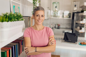 a lady in a pink t-shirt stands with her arms crossed