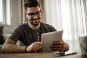 man looking at tablet - alumni survey