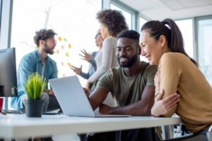 a man and woman looking at a laptop