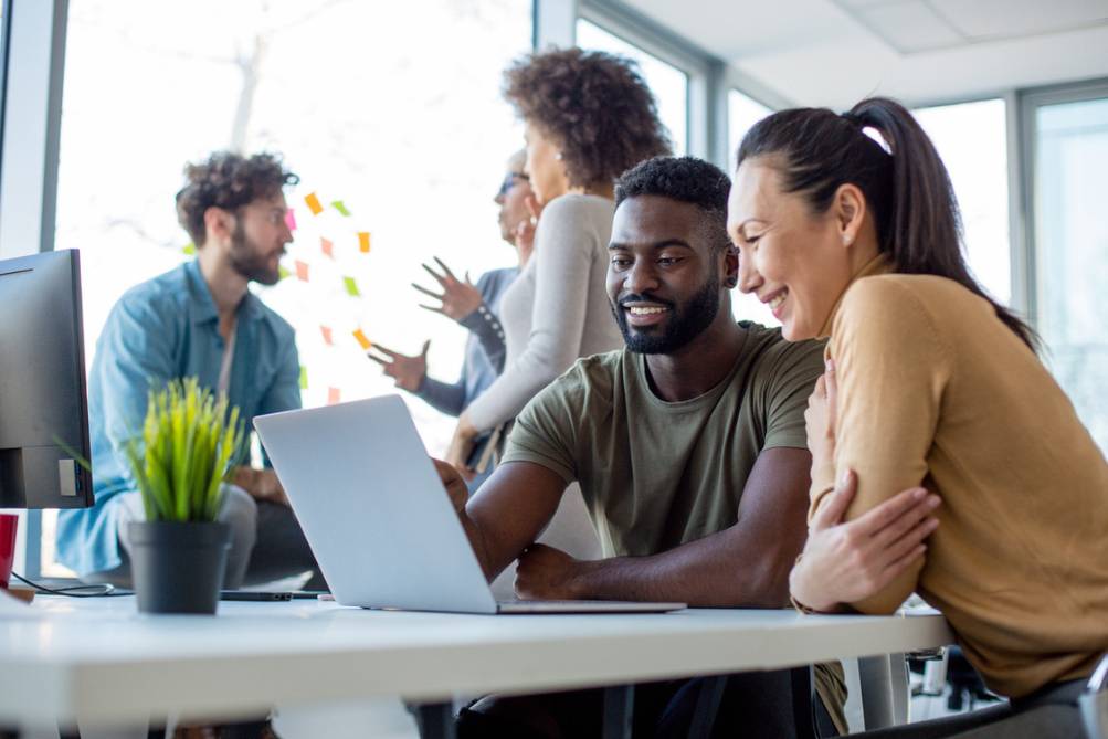 a man and woman looking at a laptop