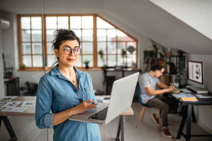 Woman holding laptop in office