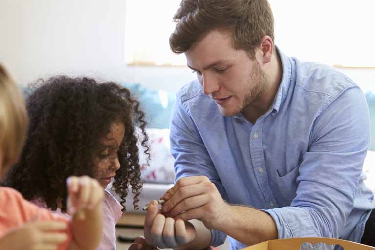 A male Montessori teacher in his classroom setting